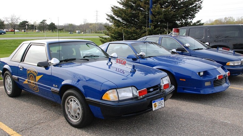 Michigan State Police cars in a parking lot -- a Mustang, Camaro, and Caprice