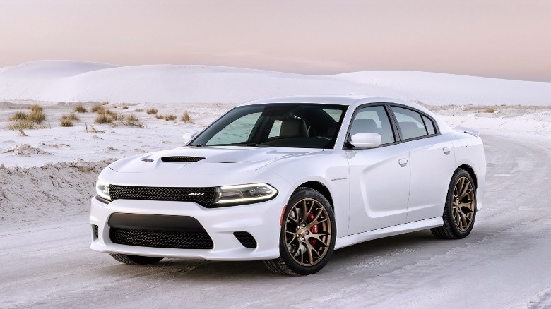 a white Dodge sedan driving in the snow