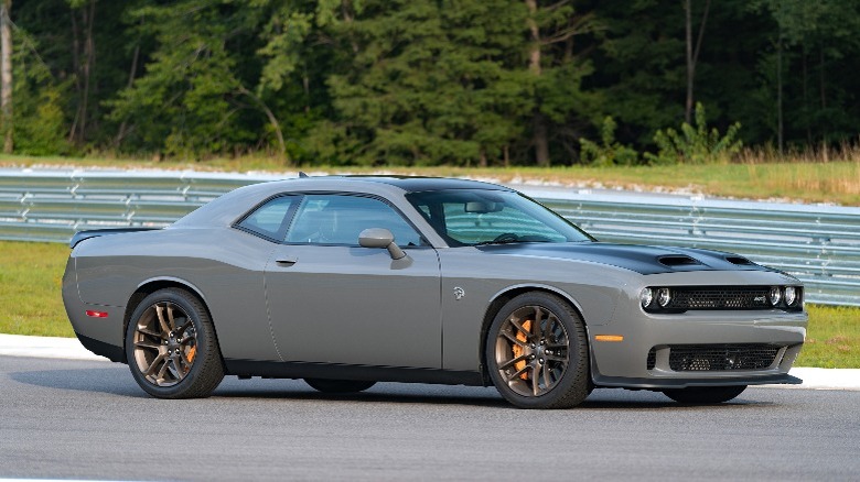 a grey Dodge Challenger driving down a road