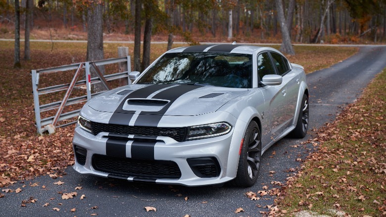 a silver Dodge Charger with black stripes on the hood