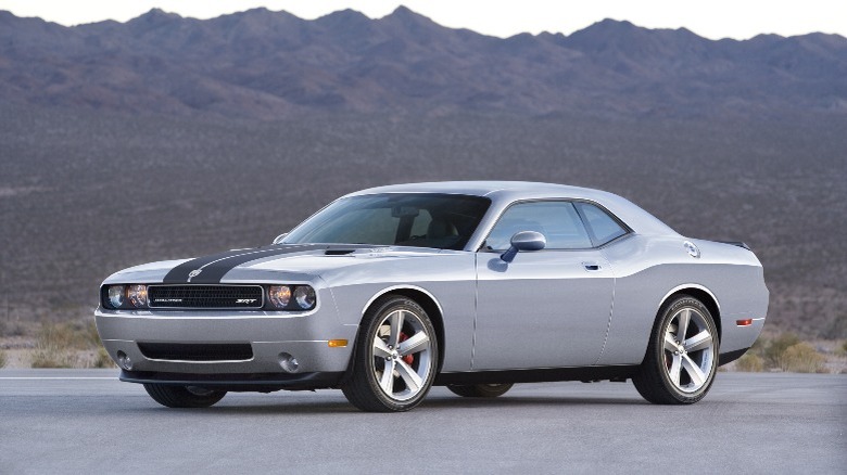 a silver Dodge Challenger SRT8 with black stripes on the hood