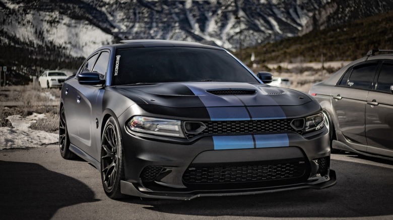 a black dodge sedan with blue sport stripe