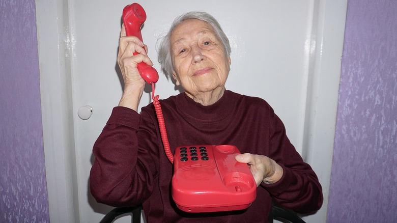 woman holding landline phone