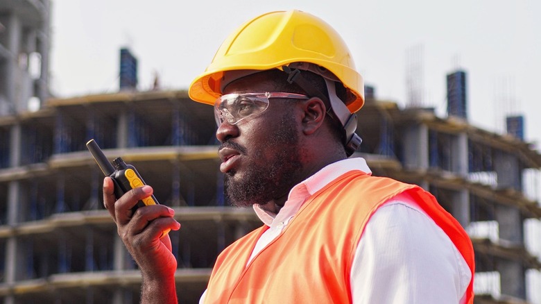 construction worker holding walkie talkie