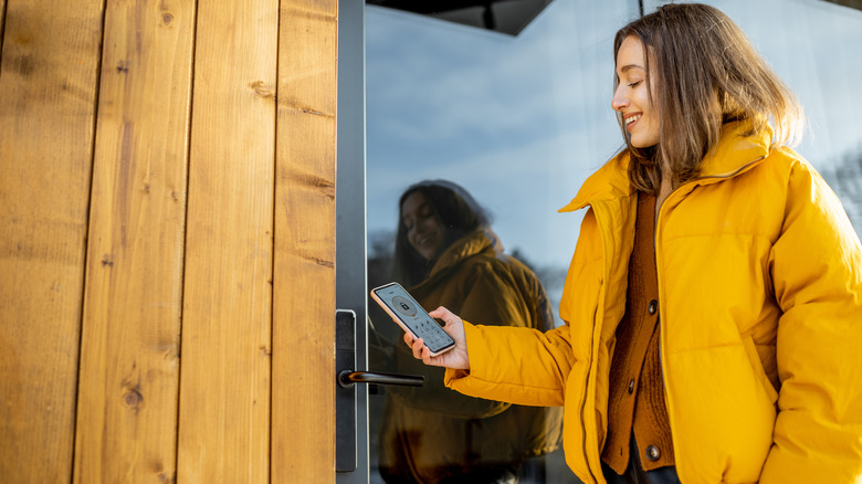 A woman pleased with her smart lock as she opens the door