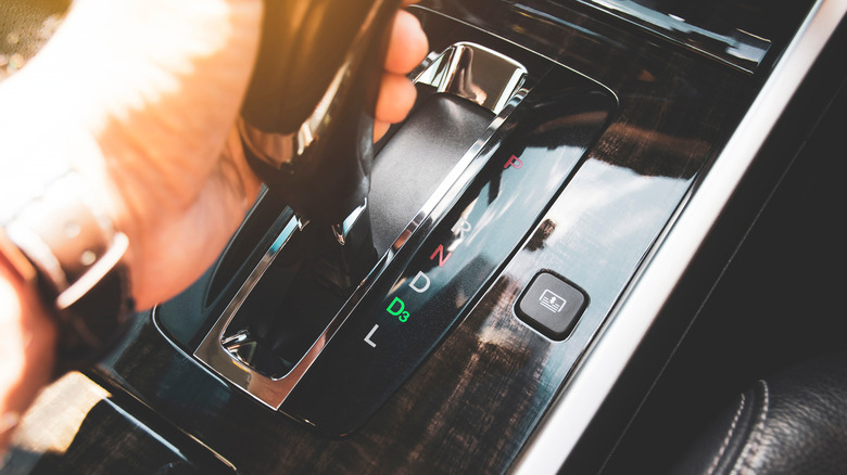 A grey car's gear shift with an overdrive (O/D) button