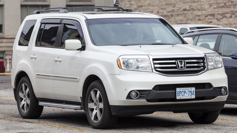 A white Honda Pilot in a parking space