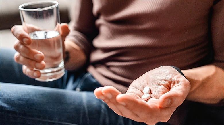 Person taking pills with water