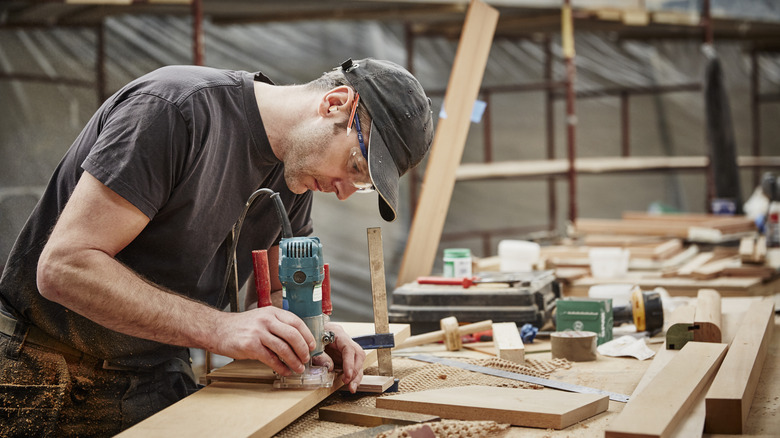 a woodworker using a router