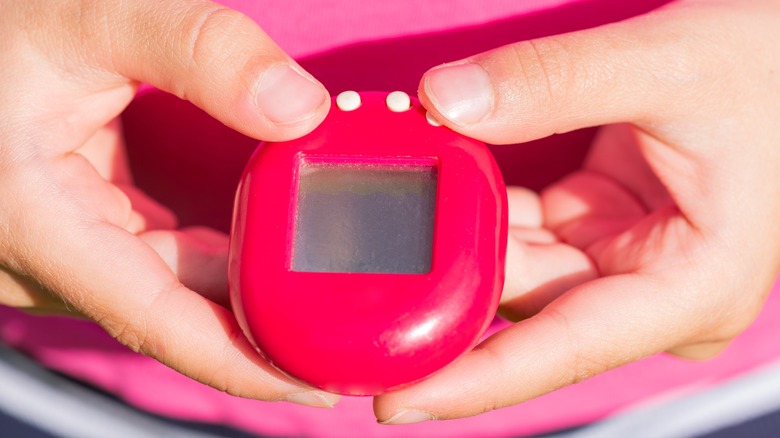 Child playing with a Tamagotchi in the 90s.