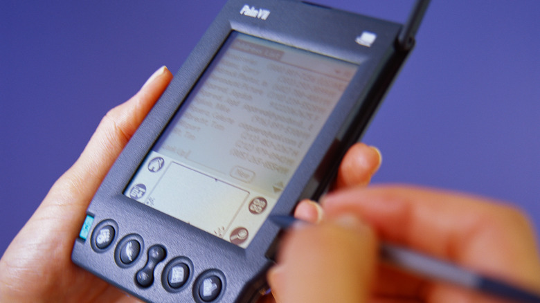 Person holding a Palm PDA with stylus.