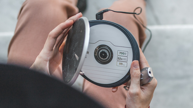 Person opening a portable CD player.