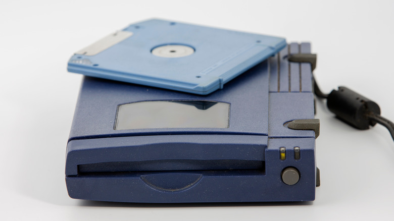 ZIP disk and drive on white background.