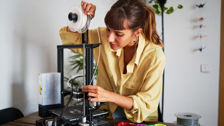 A woman using a 3D printer kept on a table