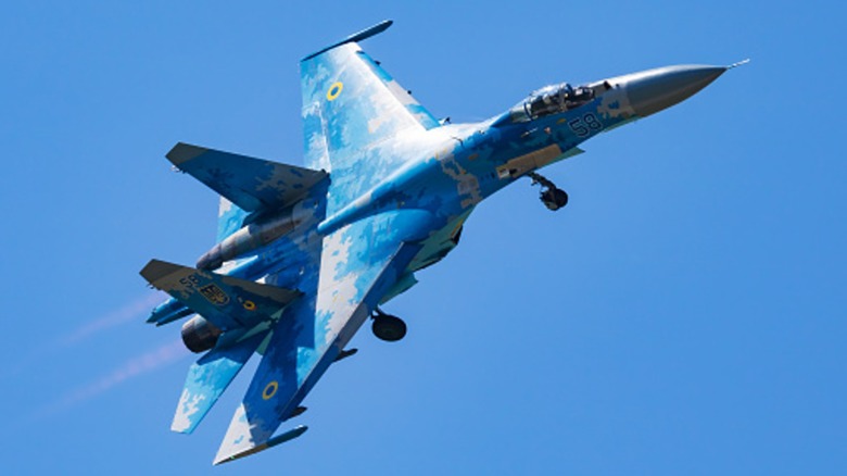 SU-27 flying against a blue sky.