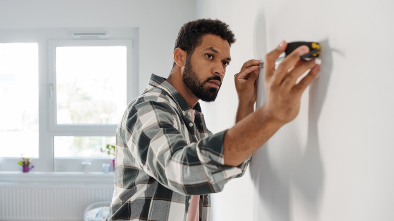 Mans uses tape measure in new apartment