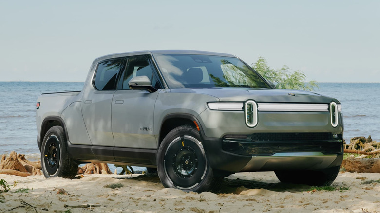 Gray Rivian R1T parked on sand