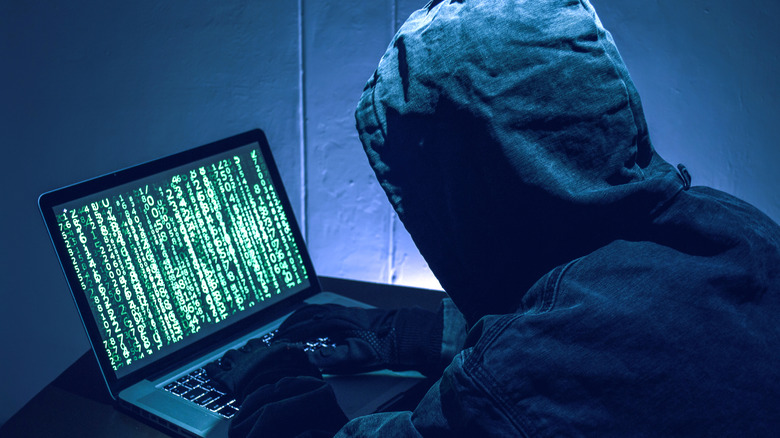 A hacker with hoodie and laptop