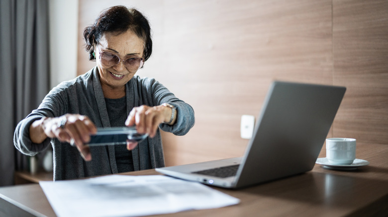 a woman scanning a document using her iPhone