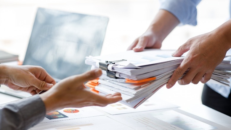 a man passing paperwork