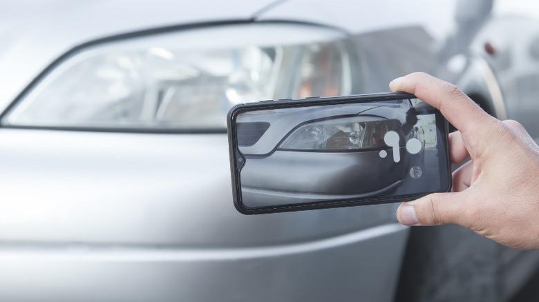 man taking photos of his car