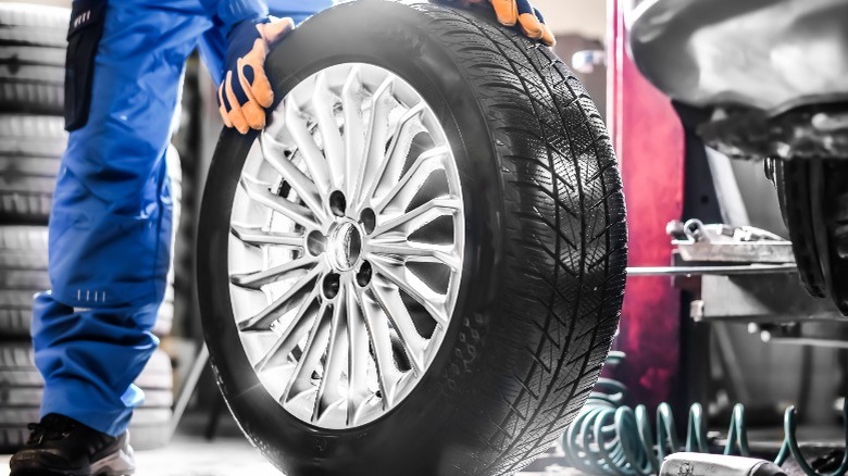 person holding a car wheel