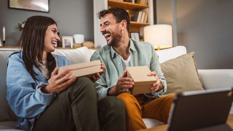 Man and woman opening presents