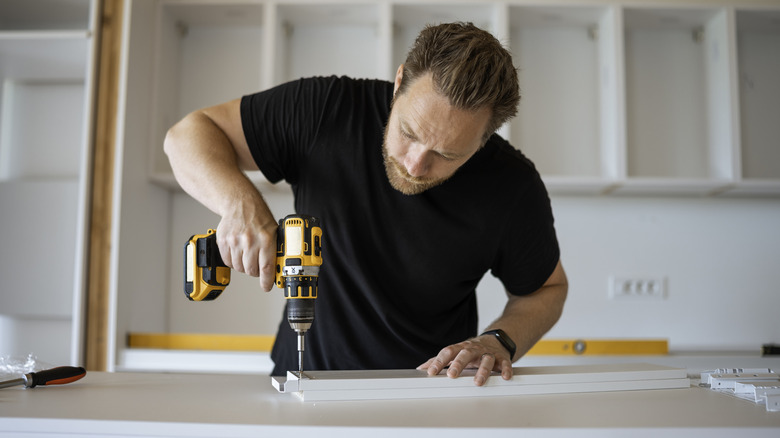 Man fitting kitchen cupboards