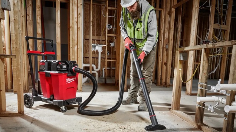 worker using Milwaukee wet/dry vac