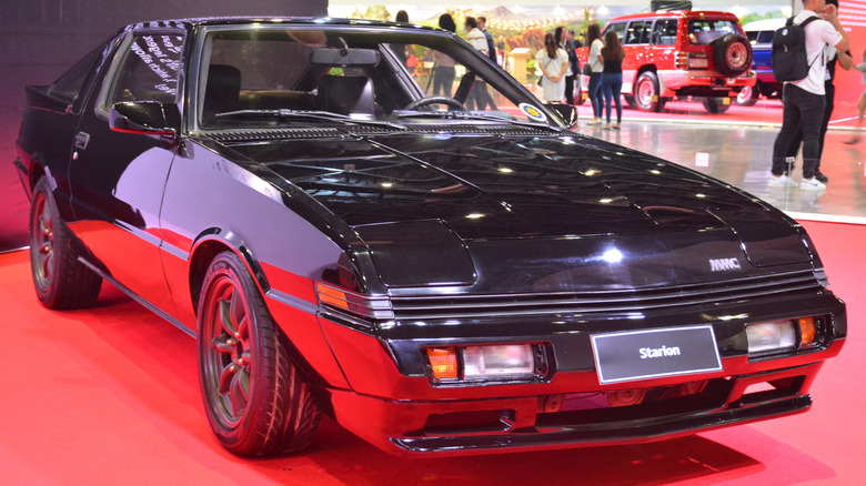 Red Mitsubishi Starion Turbo front 3/4 view on white background