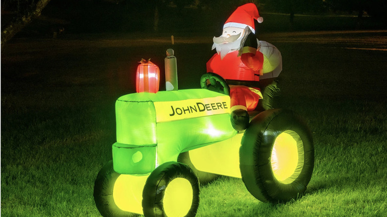 John Deere Santa Holiday Inflatable lit up on a lawn.