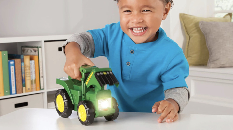 Child playing with the John Deere Tractor Flashlight.