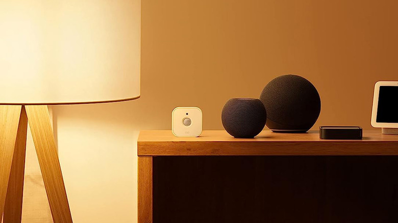 An Eve Motion Sensor next to an Apple Homepod on a table