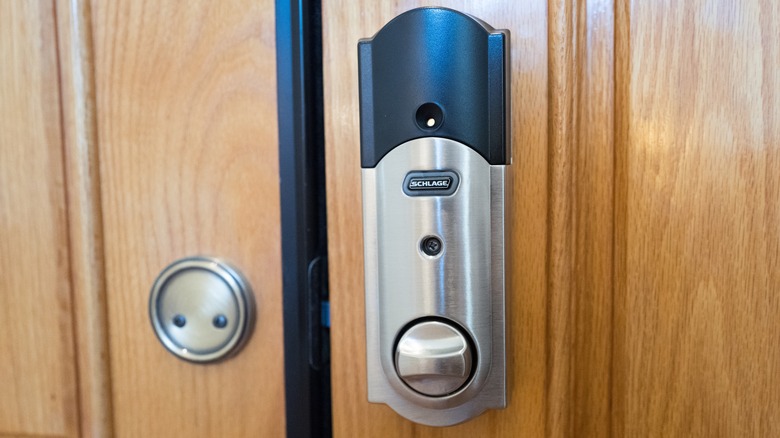 A Schlage smart door lock on a wooden door