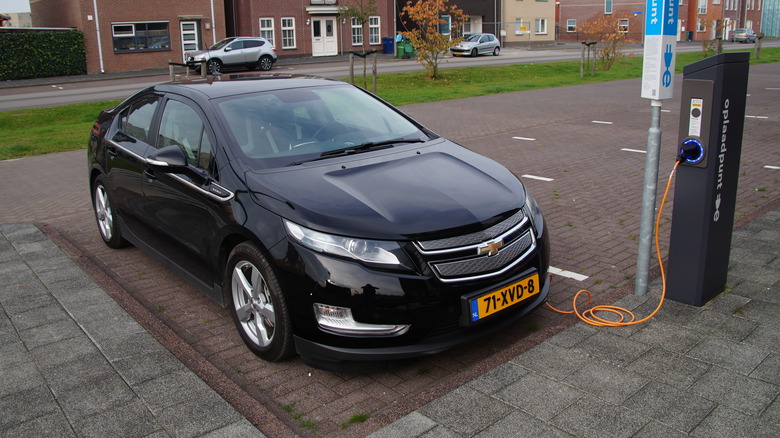 black Chevy Volt plugged into a charger