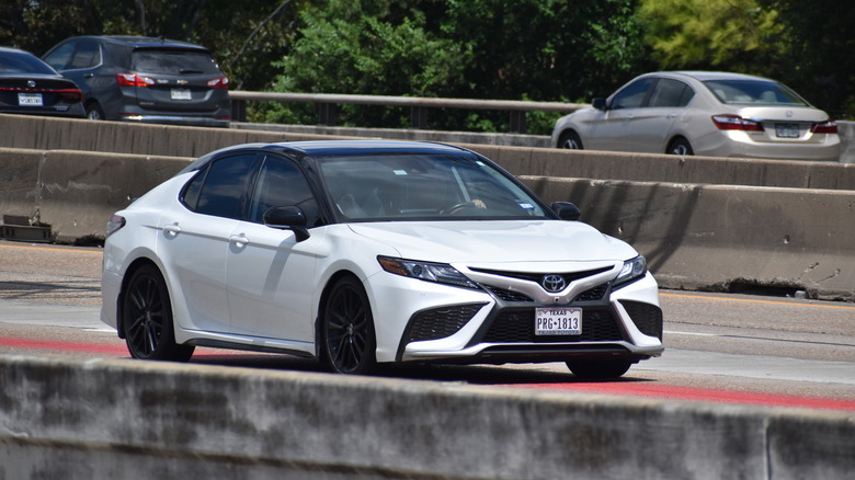 white Toyota Camry Hybrid on the highway