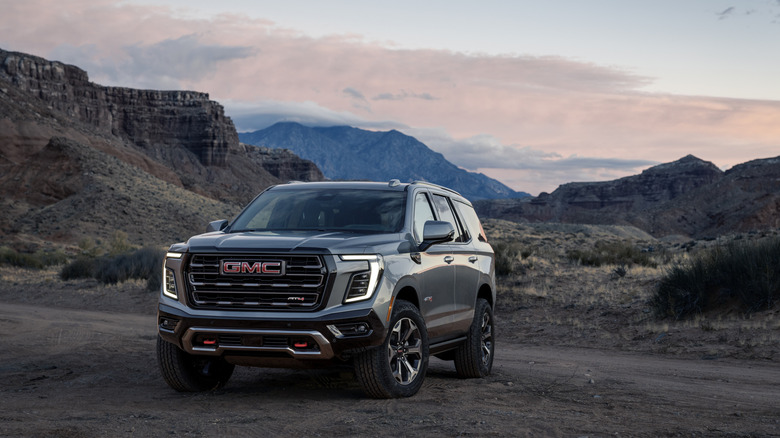 GMC Yukon SUV parked in the wilderness front 3/4 view