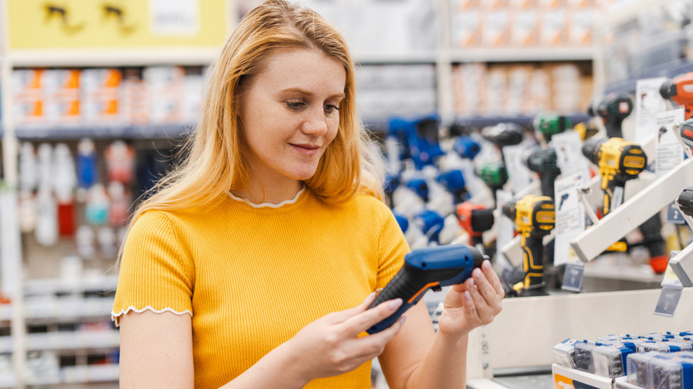 woman holding small electric screwdriver