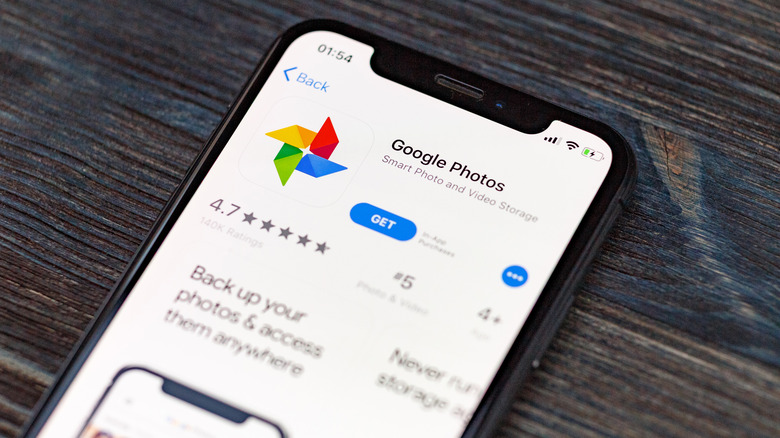 Google Photos plus application icon on Apple iPhone X screen close-up