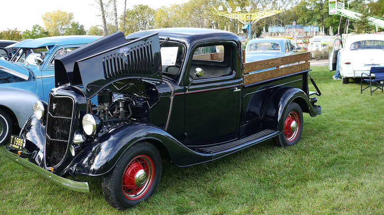 A black 1935 Ford Modle 50 Pickup at a car show