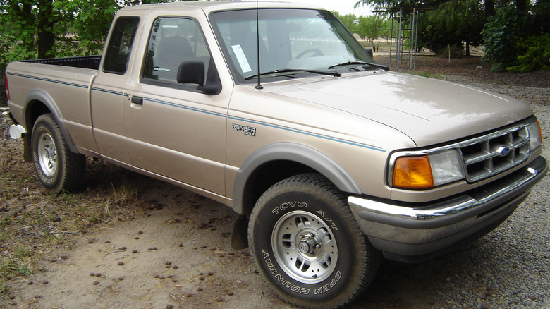 A beige Ford Ranger parked in the dirt