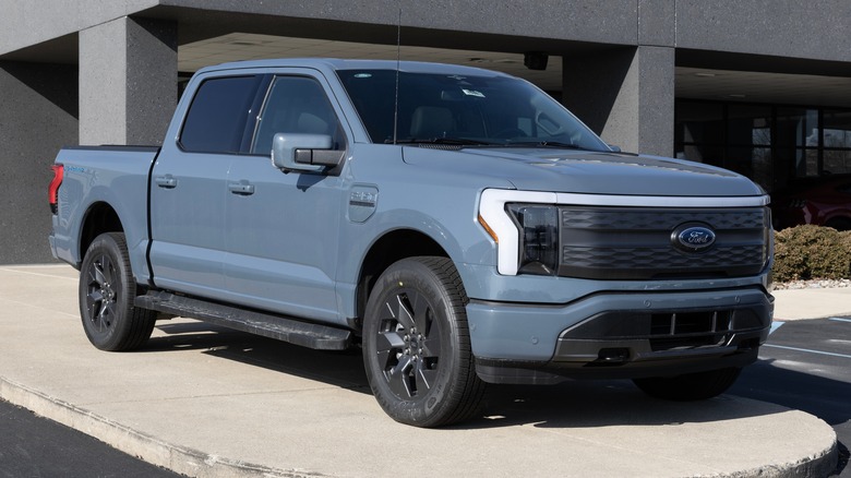 A slate blue Ford F-150 Lightning at a dealership lot