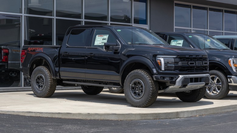 A black Ford F-150 Raptor at a dealership