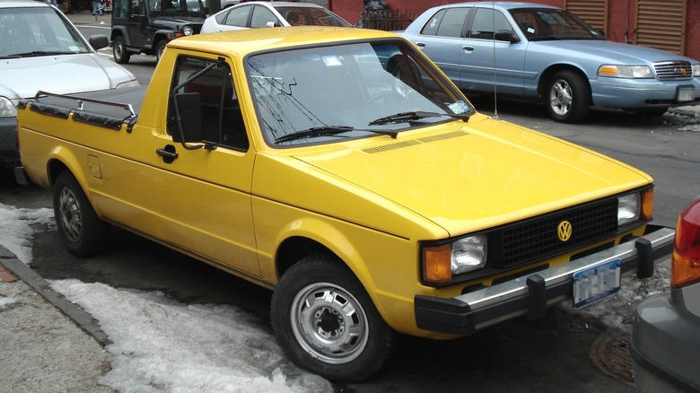 Yellow Volkswagen Rabbit Pickup parked on a sidewalk