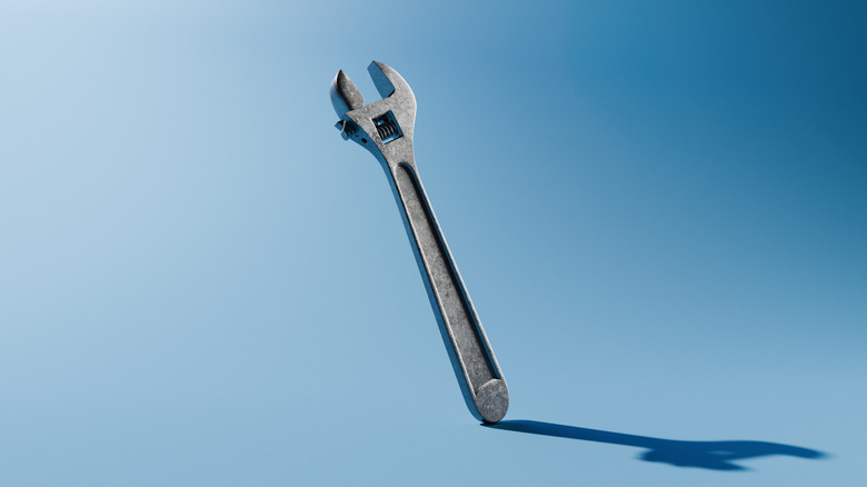 An adjustable wrench is on a blue background.