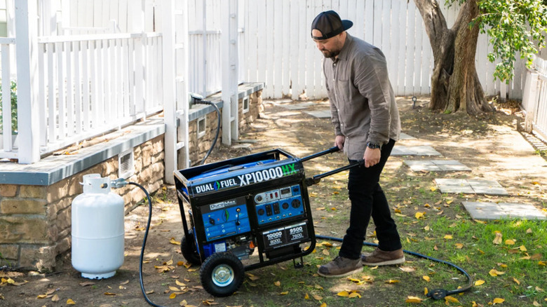 Person moving power generator with propane tank