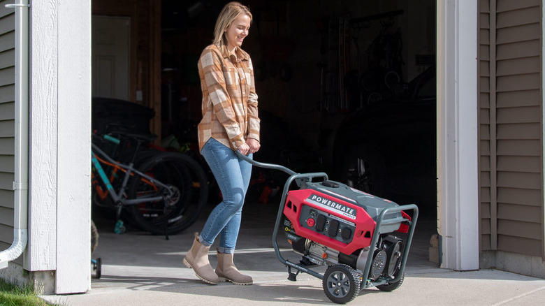 Person moving portable generator out of garage