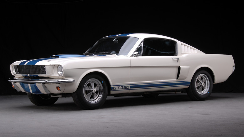 A white Ford Mustang with blue racing stripes