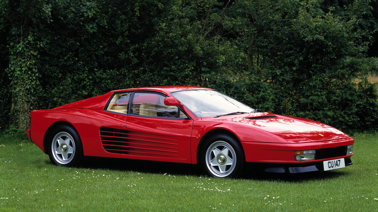 Red Ferrari Testarossa parked on turf