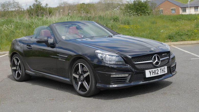 Black Mercedes-Benz SLK 55 AMG roadster on an empty parking lot